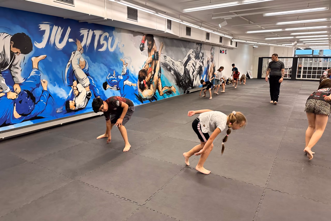 Kindertraining vor der gemalten Jiu-Jitsu-Wand im Studio